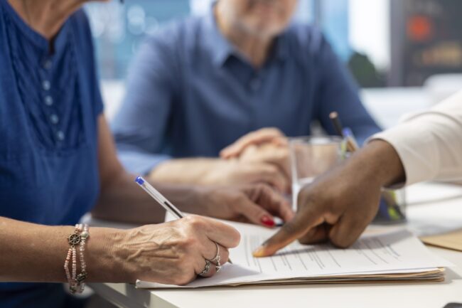 Middle aged woman signing retirement plan contract to secure the future income